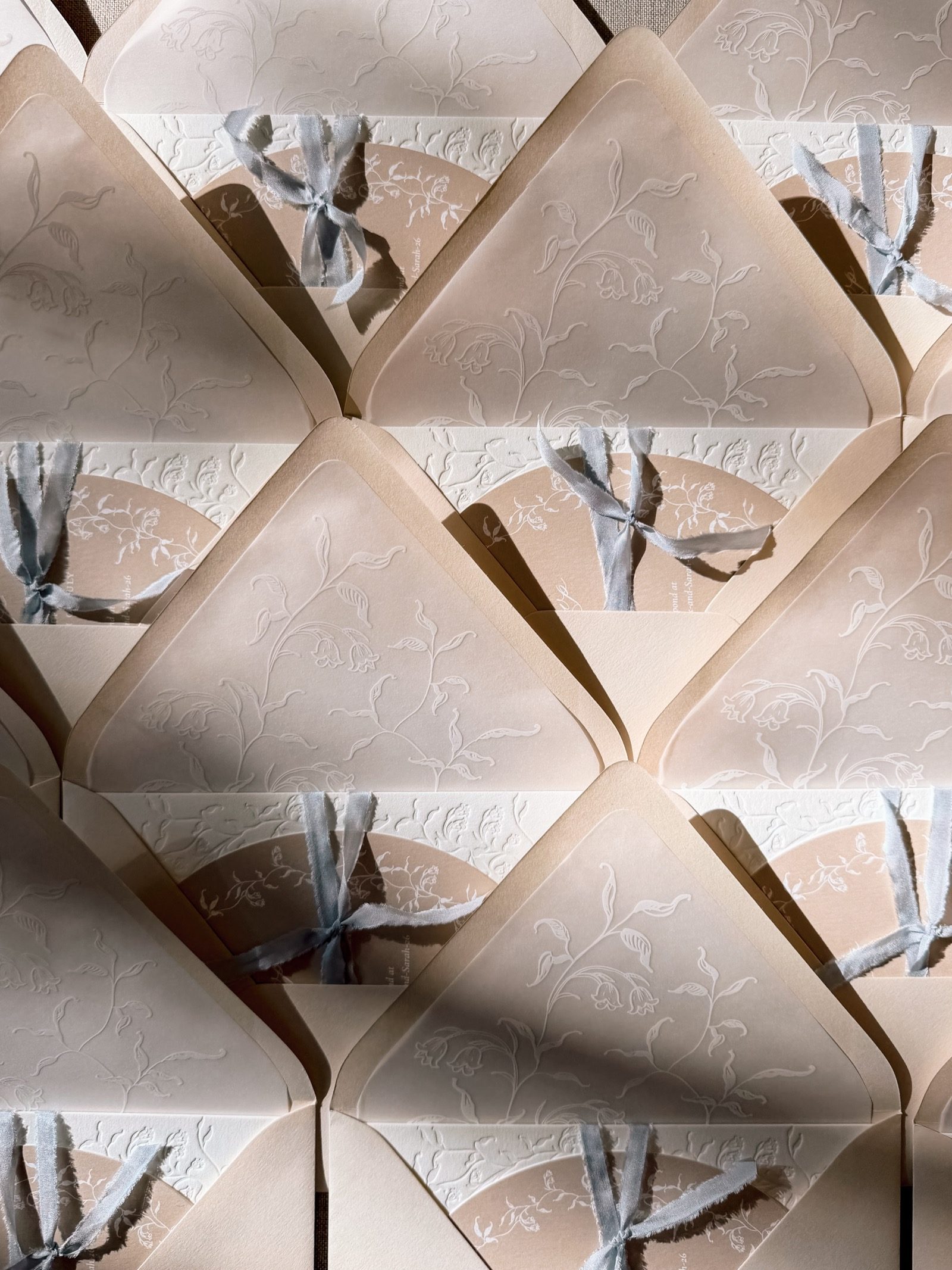 Blush invitation suites with vellum wraps and silk ribbon
