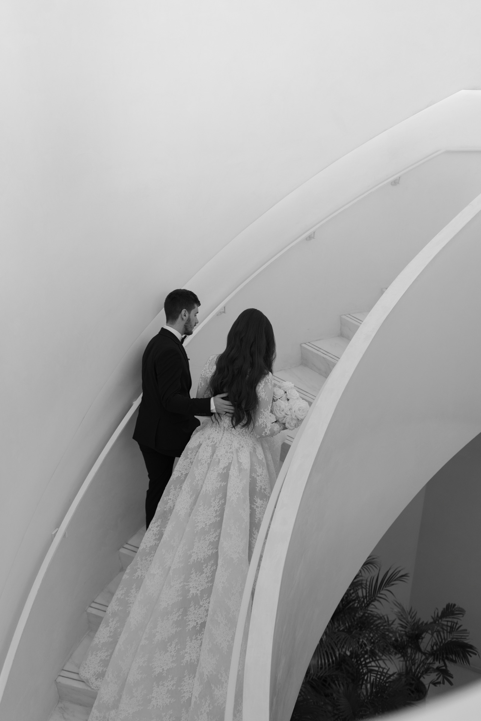 Bride and groom on a sweeping marble staircase